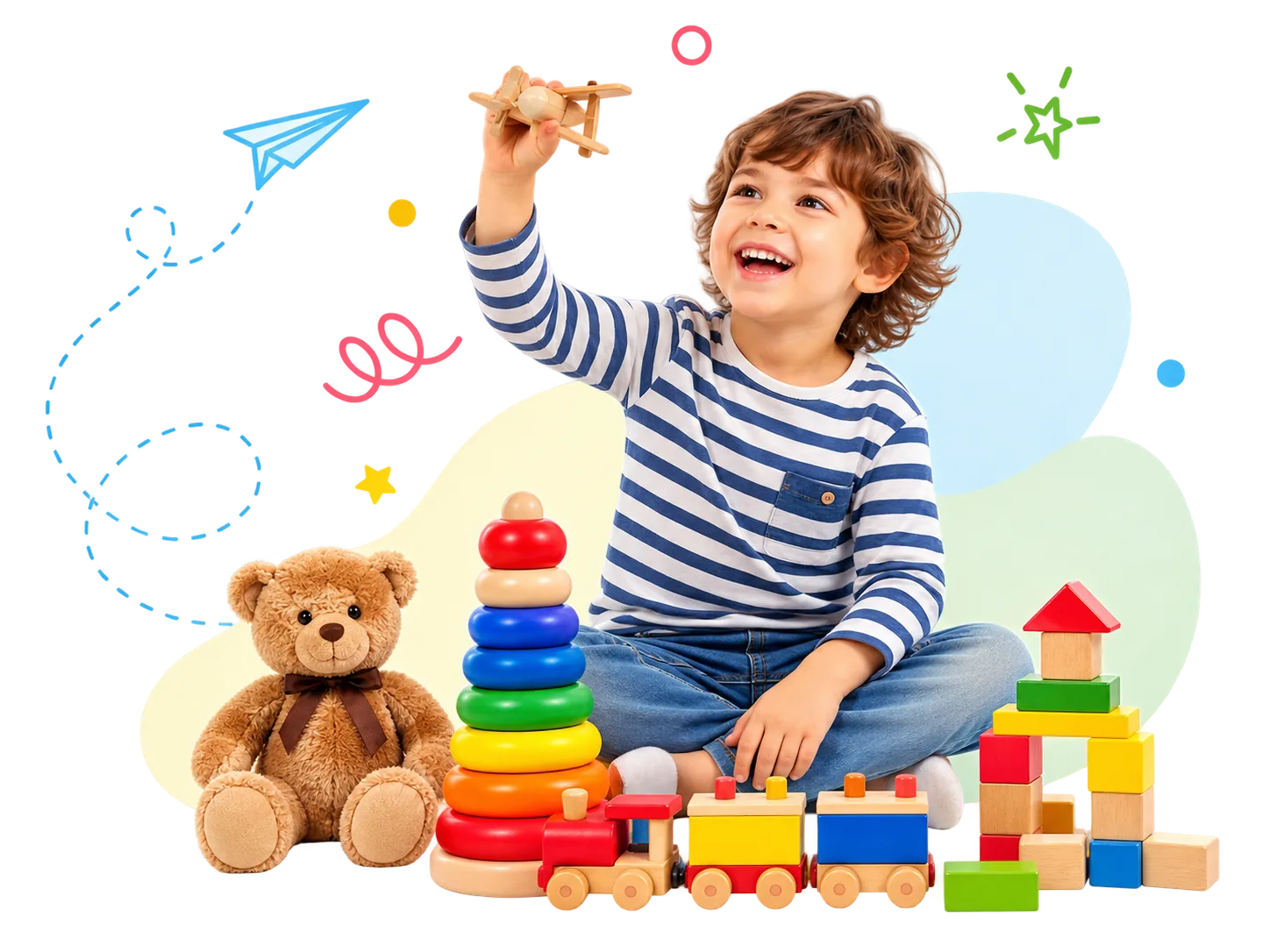 A happy young child holding up a wooden toy aeroplane, surrounded by colourful stacking rings, building blocks, a wooden train and a teddy bear.